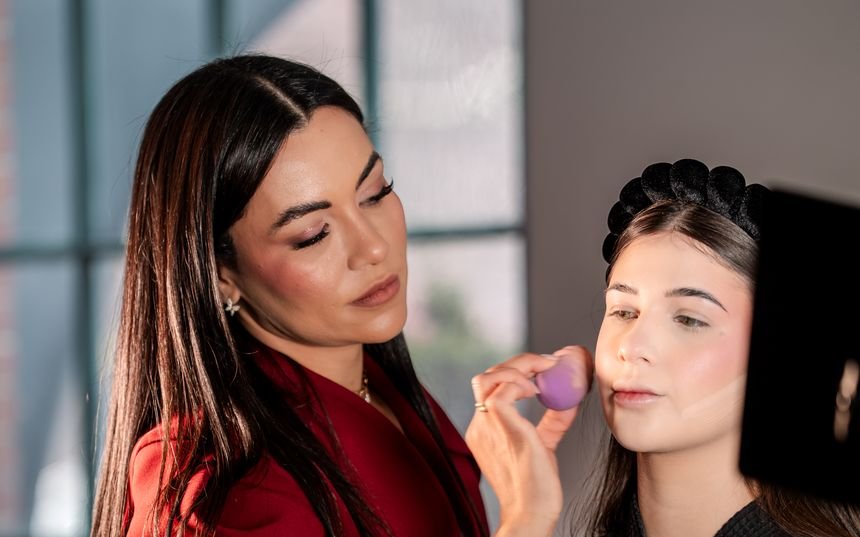 Danila Ribeiro aplicando maquiagem com esponja em uma cliente